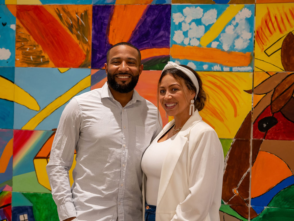 Event attendees in front of colorful artwork